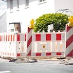 Bright road barrier with striped pattern signals construction on suburban street.