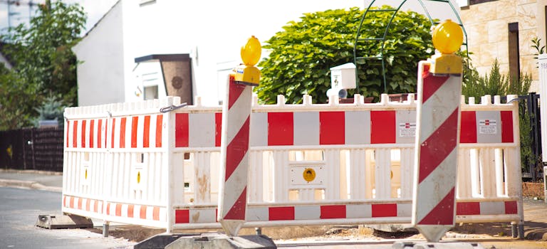Bright road barrier with striped pattern signals construction on suburban street.
