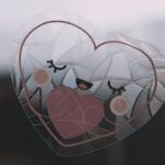Adorable heart-shaped sticker with a smiling face on a window, creating a charming decoration.