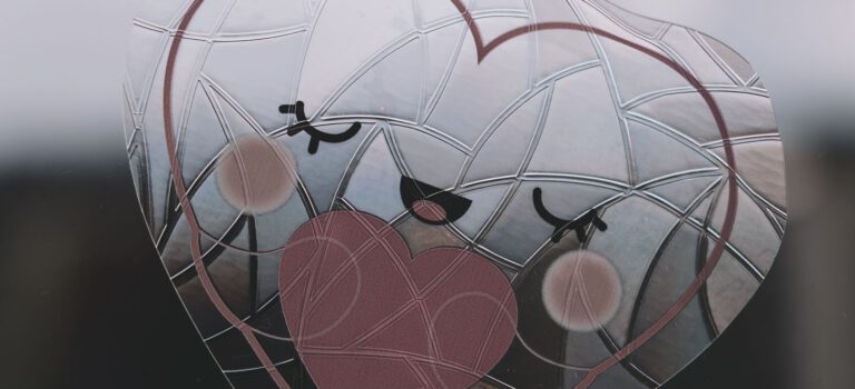 Adorable heart-shaped sticker with a smiling face on a window, creating a charming decoration.