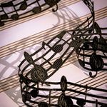 Artistic black lace musical notes elegantly arranged on sheet music, creating a captivating visual.