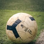 Detailed view of a classic soccer ball on a lush green field, perfect for sports enthusiasts.