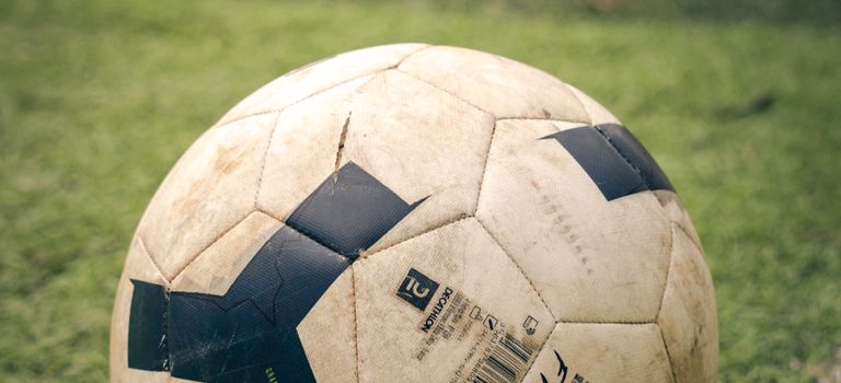 Detailed view of a classic soccer ball on a lush green field, perfect for sports enthusiasts.